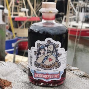 Flasche mit rotem Hafenmacker Seemannsblut Aroniabeerenlikör im Hafen